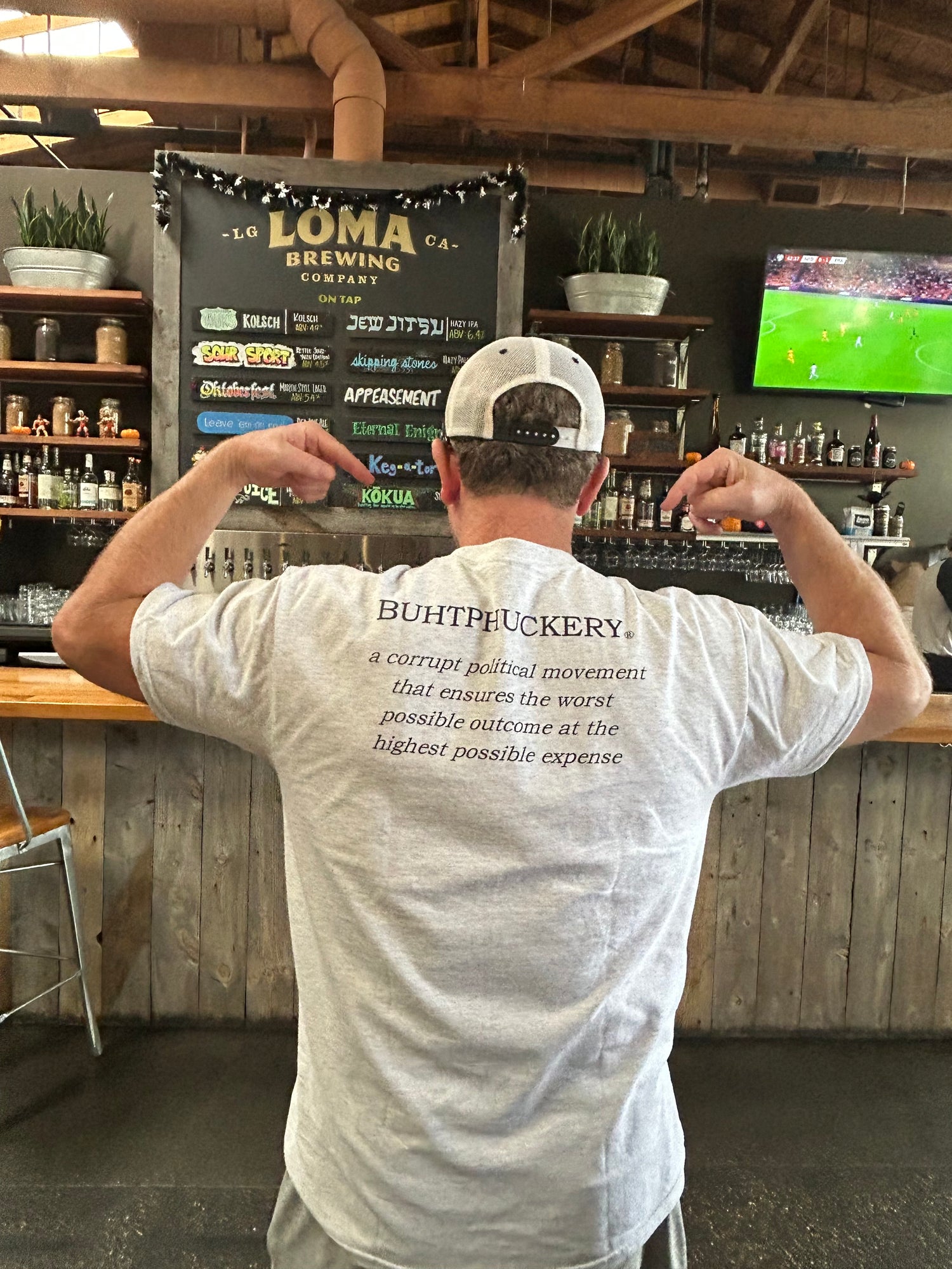 image of man wearing buhtphuckery t-shirt in bar